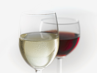 Glasses of white and red wine on white background - KSWF000999