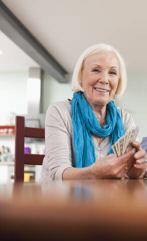 Deutschland, Leipzig, Seniorin beim Kartenspielen, lizenzfreies Stockfoto