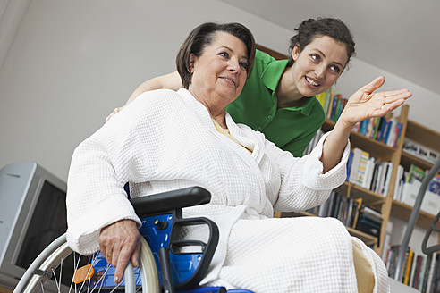 Deutschland, Leipzig, Ältere Frau sitzt im Rollstuhl, während eine andere Frau schiebt - WESTF018837