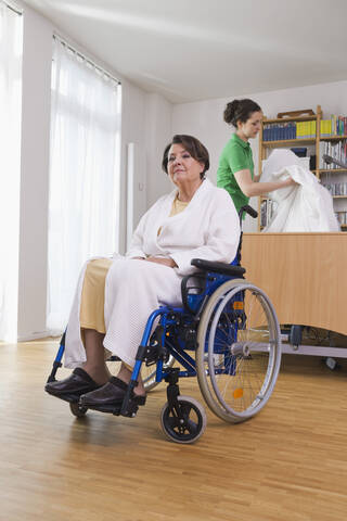 Deutschland, Leipzig, Ältere Frau sitzt im Rollstuhl, lizenzfreies Stockfoto