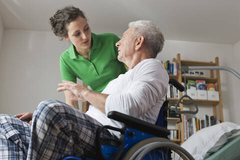 Germany, Leipzig, Man on wheelchair, talking with woman stock photo