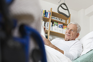 Deutschland, Leipzig, Älterer Mann liegt auf einem Krankenbett und zeichnet - WESTF018850