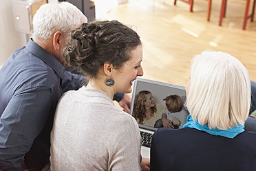 Deutschland, Leipzig, Mann und Frau betrachten Bilder auf Laptop - WESTF018863