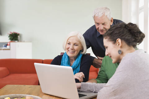 Germany, Leipzig, Men and women watching pictures on laptop stock photo