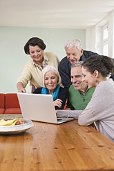 Deutschland, Leipzig, Männer und Frauen schauen sich Bilder auf dem Laptop an - WESTF018873