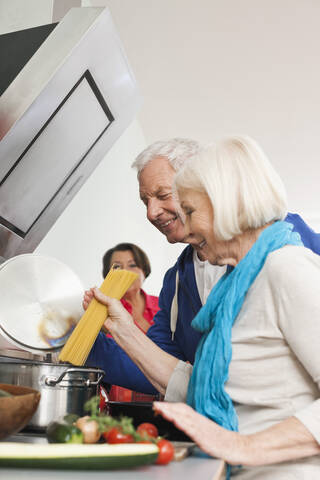 Germany, Leipzig, Man and women cooking food, smiling stock photo