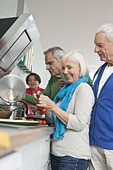Germany, Leipzig, Senior men and women cooking food - WESTF018894