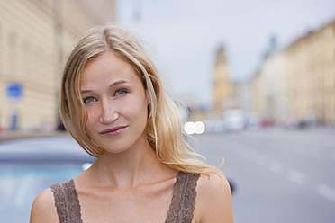 Germany, Bavaria, Munich, Young woman in front of Bavarian State Library at Ludwigstrasse - TCF002811