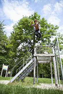 Deutschland, Bayern, Junger Mann beim Parcourtraining im Park - MAEF004794