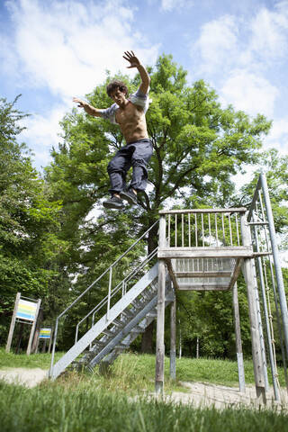 Deutschland, Bayern, Junger Mann beim Parcourtraining im Park, lizenzfreies Stockfoto