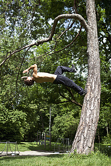 Deutschland, Bayern, Junger Mann beim Parcourtraining im Park - MAEF004798