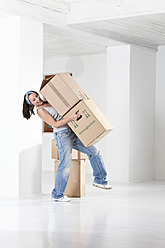 Young woman carrying cardboard boxes - MAEF004733