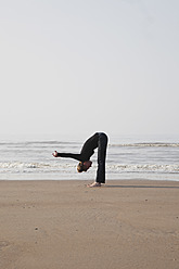 Belgien, Junge Frau beim Sport an der Nordsee - GWF001862