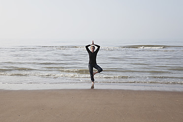 Belgium, Young woman exercising at North Sea - GWF001865