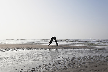 Belgien, Junge Frau beim Sport an der Nordsee - GWF001870