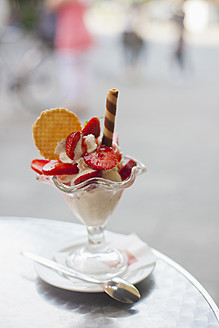 Germany, Munich, Strawberry sundae with biscuits on table - FLF000085