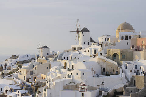 Griechenland, Windmühle mit gepflastertem Weg und grünem Tor im traditionell griechischen Dorf Oia auf Santorin, lizenzfreies Stockfoto