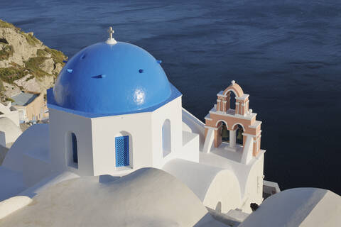 Griechenland, Blick auf die weiß getünchte Kirche und den Glockenturm im Dorf Oia, lizenzfreies Stockfoto