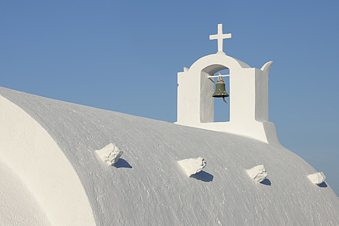 Griechenland, Weiß getünchte traditionell griechische Kirche mit Glockenturm und Kreuz in Oia auf Santorin - RUEF000960