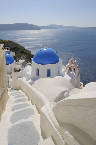 Griechenland, Santorin, Blick auf die weiß getünchte Kirche und den Glockenturm von Oia, lizenzfreies Stockfoto