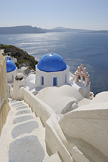 Griechenland, Santorin, Blick auf die weiß getünchte Kirche und den Glockenturm von Oia - RUEF000968