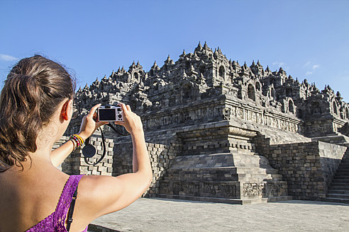 Indonesien, Junge Frau beim Fotografieren des Borobudur-Tempels - MBEF000428