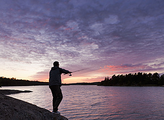 Schweden, Junger Mann beim Fischen im Sonnenuntergang - FLF000113