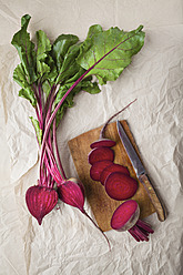 Sliced beetroots with knife and chopping board on parchment paper - ECF000027