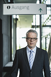 Deutschland, Stuttgart, Geschäftsmann stehend in Bürogebäude, Porträt - MFPF000193