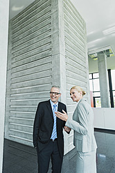 Germany, Stuttgart, Business people in office lobby, smiling - MFPF000229