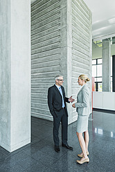 Deutschland, Stuttgart, Geschäftsleute im Gespräch in der Büro-Lobby - MFPF000230