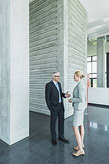Germany, Stuttgart, Business people having discussion at office lobby - MFPF000230