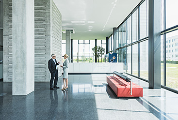 Germany, Stuttgart, Business people having discussion at office lobby - MFPF000231