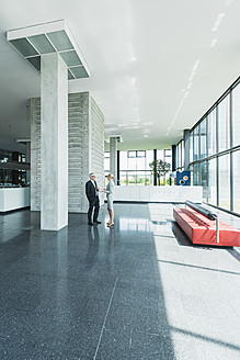 Germany, Stuttgart, Business people having discussion at office lobby - MFPF000232