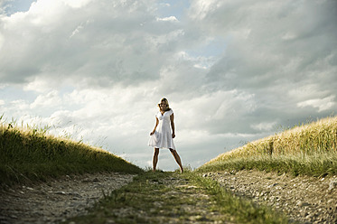 Germany, Bavaria, Mature woman standing in grain field - RNF000965