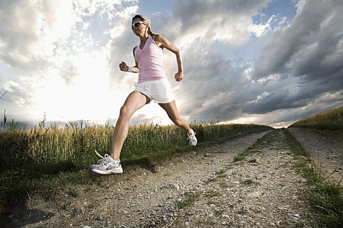 Germany, Bavaria, Mature woman running in grain field - RNF000974