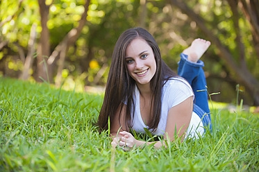 USA, Texas, Teenager-Mädchen auf Gras liegend, lächelnd, Porträt - ABAF000143