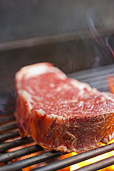 USA, Texas, Grilling rib eye steak, close up - ABAF000152