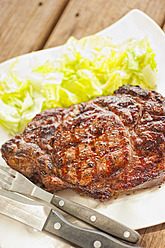 Grilled beef rib eye steak with salad on silverware plate - ABAF000158