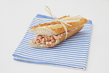 Baguette-Sandwich mit gekochten Shrimps auf Geschirrtuch - GWF001933