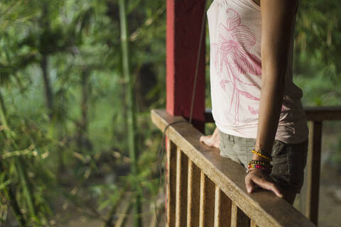 Indonesien, Junge Frau entspannt auf Veranda, lizenzfreies Stockfoto
