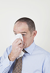 Businessman with blowing nose, close up - GWF001947