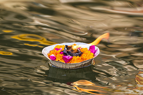 Indien, Uttar Pradesh,Blattschale mit Blumen und Öllampe schwimmend auf dem Fluss Ganges - FOF004170