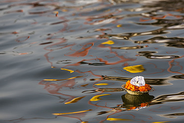 India, Uttar Pradesh, Leaf bowl with oil lamp floating on river Ganges - FOF004181