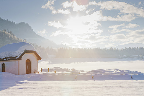 Austria, View of small chapel with backlight in winter landscape near Saalbach - FLF000128