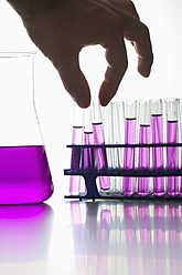 Chemiker hält Reagenzglas vor weißem Hintergrund, Nahaufnahme - FLF000130