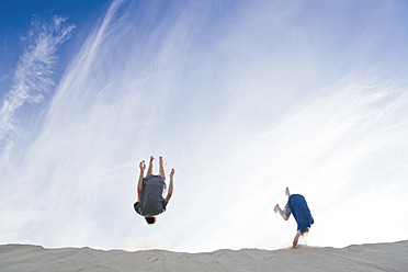 Frankreich, Zwei Jungen springen auf eine Sanddüne - MSF002724