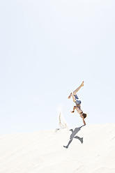 France, Boy jumping on sand dune - MSF002730