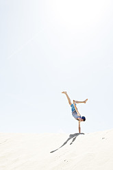 France, Teenage boy making handstand on sand dune - MSF002750