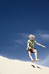 France, Boy jumping on sand dune - MSF002746